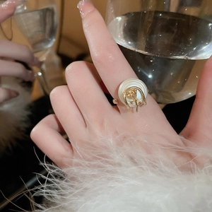 Vue détaillée d'une bague rose dorée avec base en nacre portée au doigt