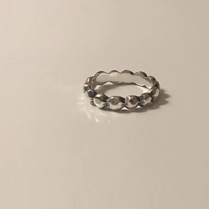 Minimalist 925 sterling silver ring with geometric faceted design on beige background