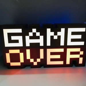 Macro shot of colorful LED pixels on Game Over sign night lamp with glowing orange light