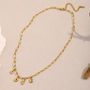 Detail of 18K gold plated paperclip chain necklace featuring LOVE letter pendants