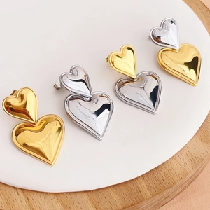 Detail of two-tone gold and silver heart earrings with polished titanium finish