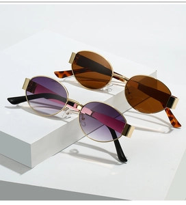 Detailed close-up of oval metal frame sunglasses with gradient and brown lenses