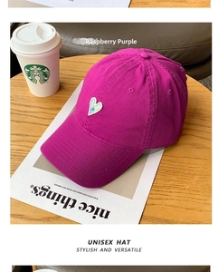 Raspberry purple cotton baseball cap with heart embroidery on a wooden table setup