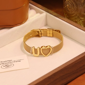 Bracelet en maille dorée avec cœur et lettre U présenté dans un coffret en bois de luxe