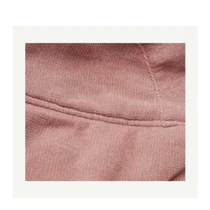 Close-up of pink corduroy fabric with fine striped texture and professional stitching
