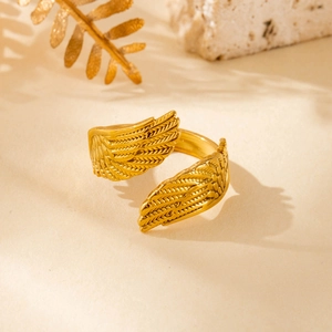 Adjustable gold wing heart open ring in stainless steel on minimalist elegant stone pedestal