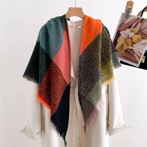 Detail of colorful checkered scarf with green, orange and red fringe tassels