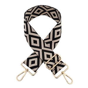 Close-up of black and white geometric diamond woven strap with gold metal swivel clasps