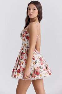Side view detail of a white floral mini dress featuring a backless A-line cut and thin straps