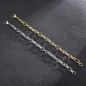 Close-up of gold and silver stainless steel cable chains on black textured background