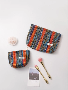 Bohemian woven makeup bag set with colorful stripes and floral zipper on grey background