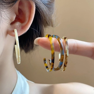 Macro shot of retro resin C-shape hoop earrings with vintage tortoiseshell texture