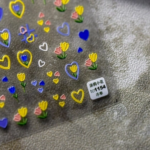 Detailed macro view of 3D embossed nail art stickers featuring tulip and heart patterns