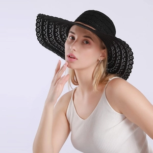 Detail of breathable black lace sun hat with wide brim and elegant brown leather trim