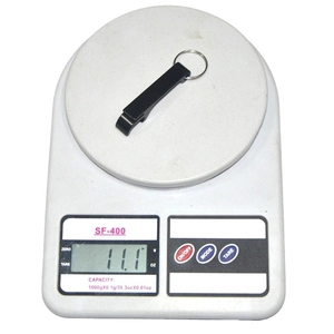 Black aluminum tiger bottle opener keychain being weighed at 11.1g on a digital scale