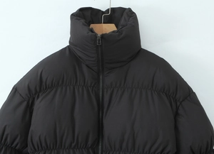 Close-up of black stand collar puffer jacket with zipper detail and quilted texture