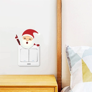 Detail of Santa Claus wall sticker decorating a light switch in a cozy bedroom setting