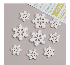 Macro view of white glittered snowflake resin accessories for Christmas DIY crafts