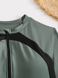 Détail du maillot de bain manches longues vert sauge avec empiècement noir et zip