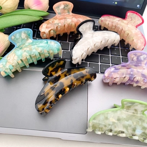Set of 6 colorful acetic acid hair claws in pastel tones on a laptop keyboard