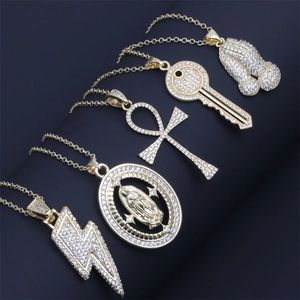 Macro view of gold pendants featuring lightning, cross, and ankh with cubic zirconia