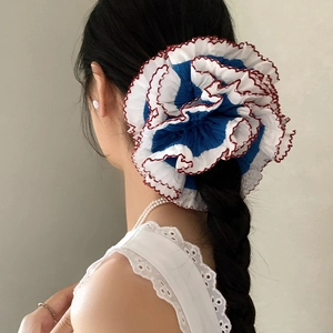 French style oversized lace scrunchie with blue and white pleats on a model's ponytail