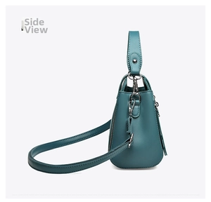 Side view of teal matte leather shoulder bag with silver zipper and adjustable strap
