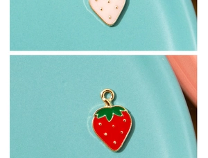 Macro view of strawberry enamel alloy charms with gold plating for DIY jewelry