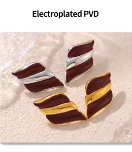 Macro shot of wing-shaped earrings with red enamel and PVD gold plating detail