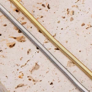 Minimalist stainless steel snake bone bracelets in gold and silver finish on stone