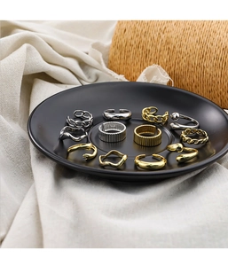 Detailed macro view of S925 silver and gold rings set on a minimalist ceramic plate