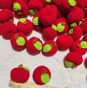 Handmade crochet red apple keychain with green leaf and measuring ruler for size scale