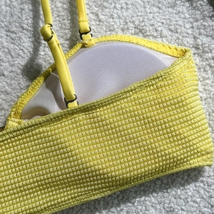 Detail of yellow waffle fabric bikini top with adjustable straps and breathable padding