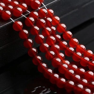Macro shot of natural red agate round beads with polished translucent finish and deep red color