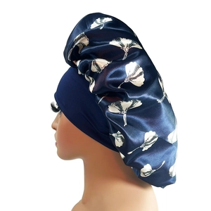 Macro detail of navy blue satin bonnet featuring white ginkgo leaf print and silky texture