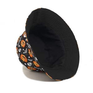 Halloween bucket hat with orange pumpkin and white skull prints on black fabric