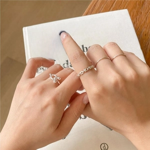 Close-up of four-piece 925 sterling silver stacked ring set with U-link chain design