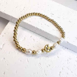 Close-up of gold beads and baroque pearls bracelet with a star and moon pendant