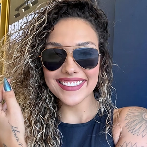 Lifestyle view of aviator sunglasses with gold metal frame and dark grey lenses for women