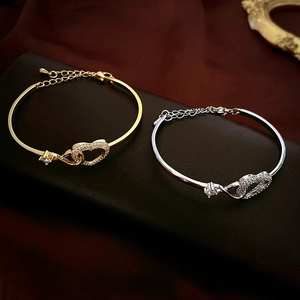 Interlocked hollow heart bracelet in gold and silver finish with pavé zircon stones