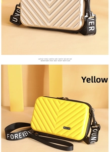 Detailed macro view of the textured hard shell mini suitcase crossbody bag with logo strap