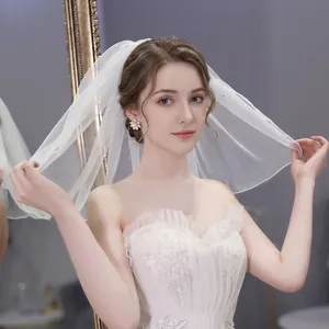 Close-up of minimalist bridal wedding veil with soft white tulle and intricate lace details