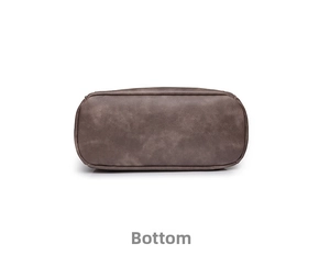 Detailed bottom view of the brown leather backpack showing stitching and oval base