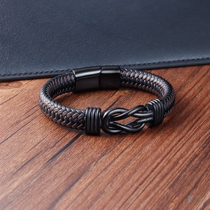 Detail of infinity knot bracelet with black braided leather and magnetic metal clasp