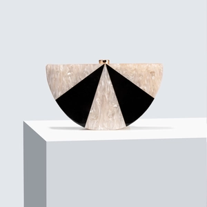 Detailed view of beige marble acrylic semi-round clutch with black triangles and gold clasp
