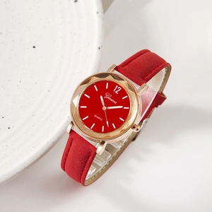 Détail d'une montre à quartz rouge avec boîtier à facettes en or rose et bracelet cuir