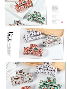 Detailed view of Christmas hair claw clips with festive patterns like Santa and reindeer