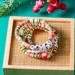 Christmas multilayer bracelet set with Santa beads and green holiday charms on a tray