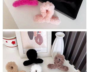 Close-up of soft plush claw clips in various colors including pink, black, and white