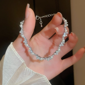 Detailed view of the lobster clasp and adjustable silver chain with white pearls and zircons